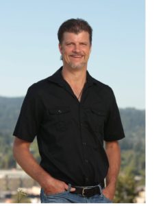 Billy smiling standing with Eugene landscape in the background.